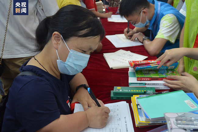 圖為彭霞參與圖書和學(xué)習(xí)用具捐贈