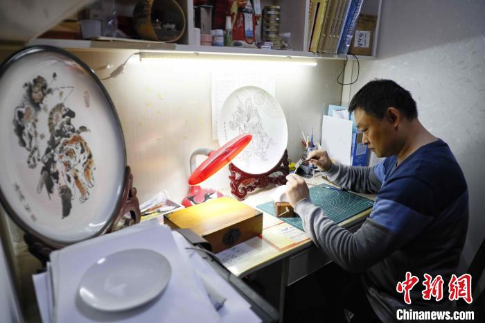 圖為黃海濤正在工作室里刻瓷 陳陽(yáng)攝
