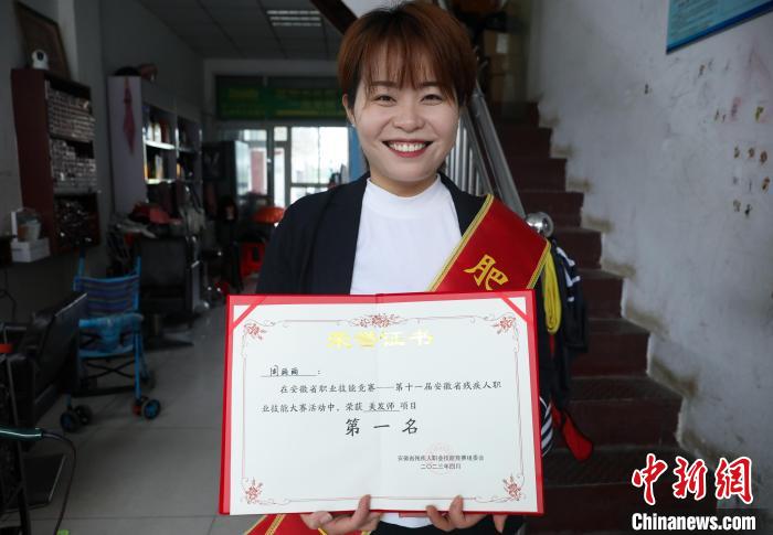 圖為周麗麗展示自己在安徽省級(jí)技能比賽中的獲獎(jiǎng)證書