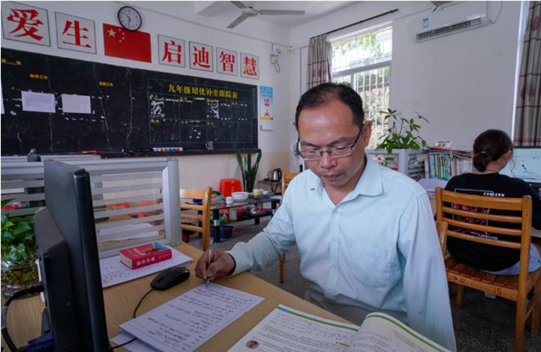 圖為多年來梁木山已習(xí)慣了單手寫教案