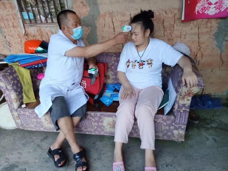 圖為馮世財(cái)上門為隔離人員測(cè)體溫