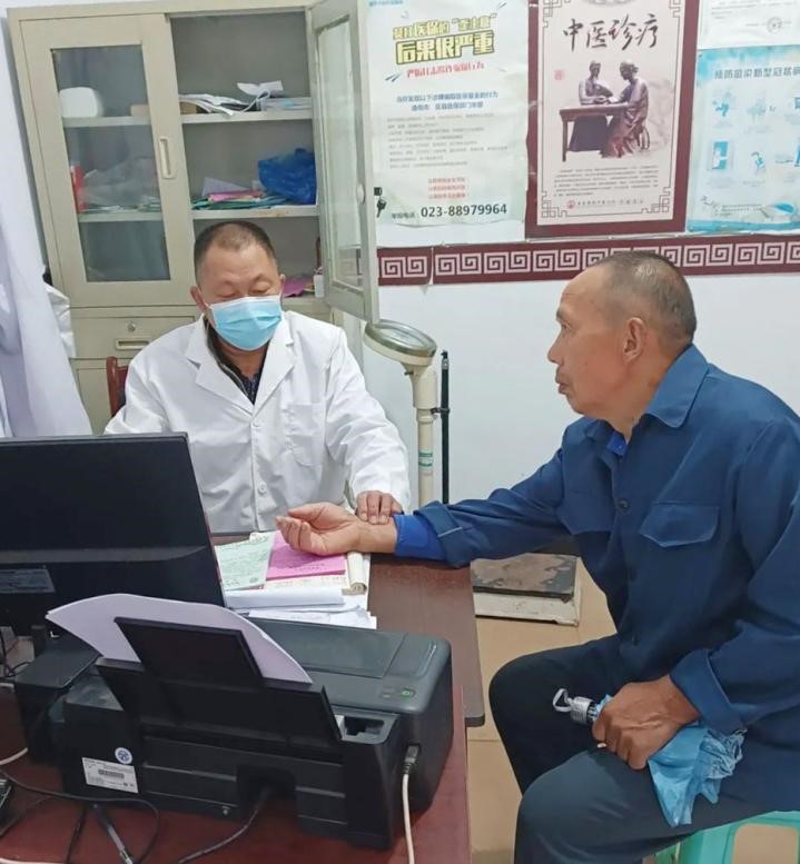 圖為馮世財(cái)為患者把脈