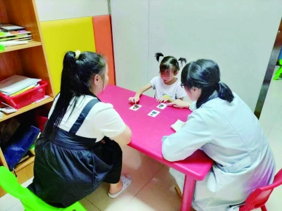 圖為工作人員為孤獨(dú)癥兒童做康復(fù)訓(xùn)練