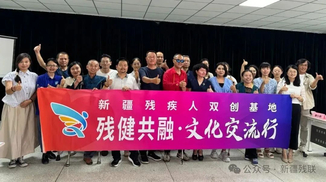圖為曹晟康和新疆殘疾人藝術(shù)家及殘疾人工作者合影