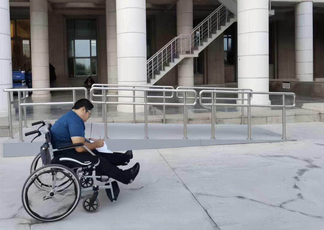 嚴宇橋在主樓正門記錄無障礙坡道測繪數(shù)據(jù)