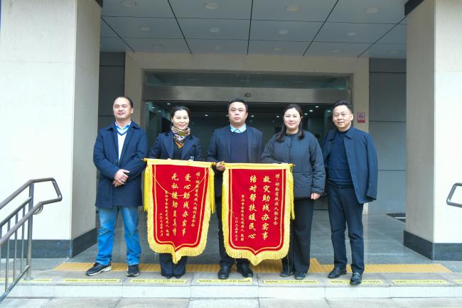 圖為資興市健輝服飾有限公司與資興市果農(nóng)富農(nóng)業(yè)科技有限公司為省殘聯(lián)贈送錦旗
