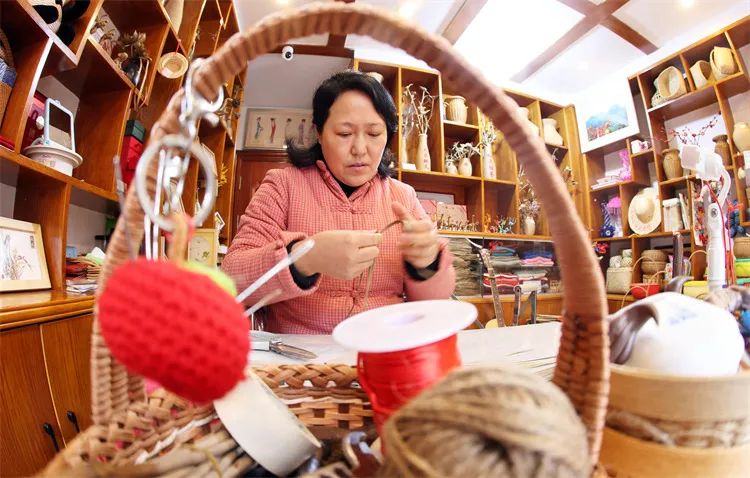 圖為李忠慧用棕葉編工藝品