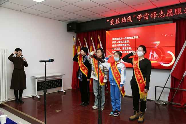 圖為天津市優(yōu)秀志愿者代表曲蕾帶領志愿者們莊嚴宣誓