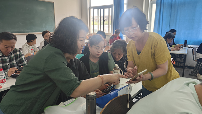 圖為老師現(xiàn)場指導(dǎo)學(xué)員制作短視頻